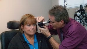 eye doctor assessing patient's vision for eye diseases