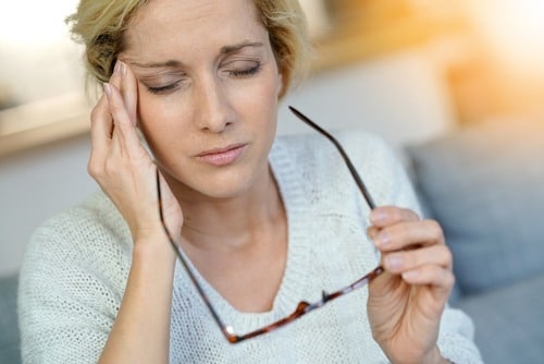 woman rubbing temples to relieve migraine