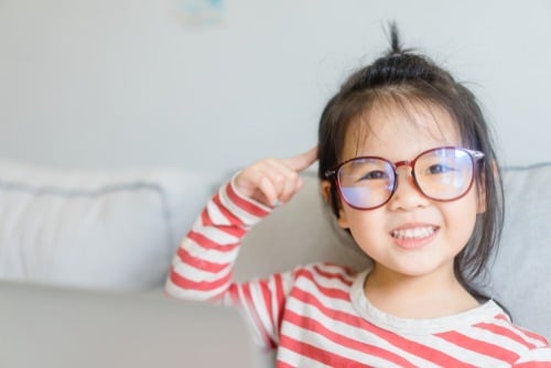 child wearing glasses and pointing to brain