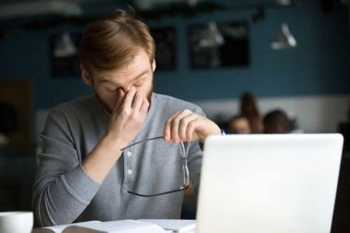man rubbing eyes after looking at a computer too long