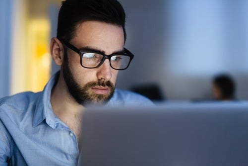 man viewing computer screen and suffering from digital eye strain