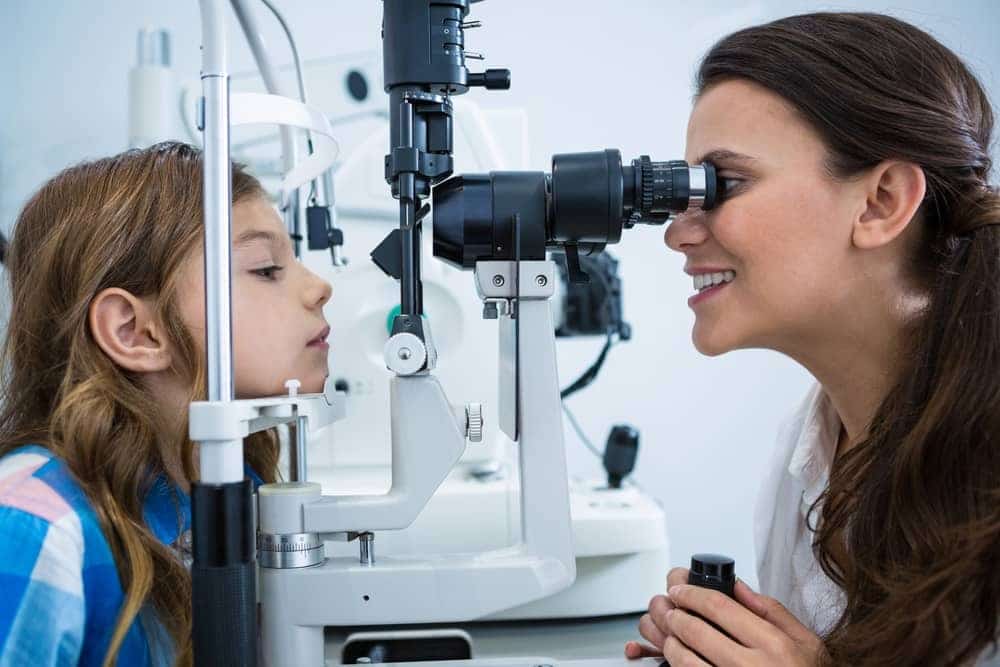 Female optometrist examining child's eye